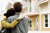 couple hugging in front of a house